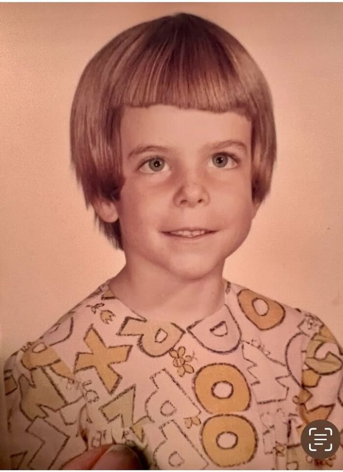 Young boy with a bowl haircut smiling in a vintage school picture, a classic funny school picture day fail moment.