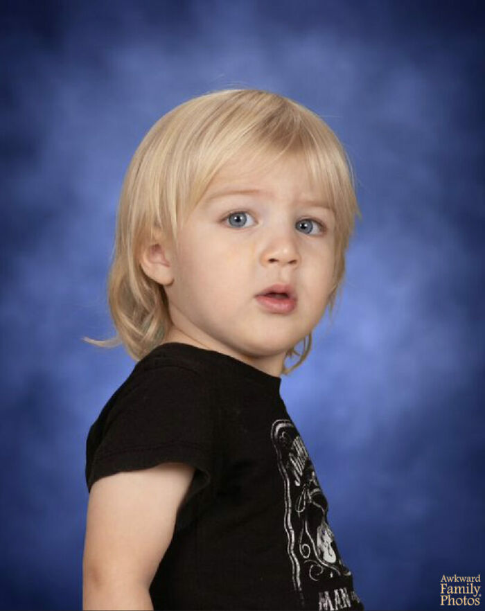 Young child with blonde hair and confused expression in a classic funny school picture day photo background.