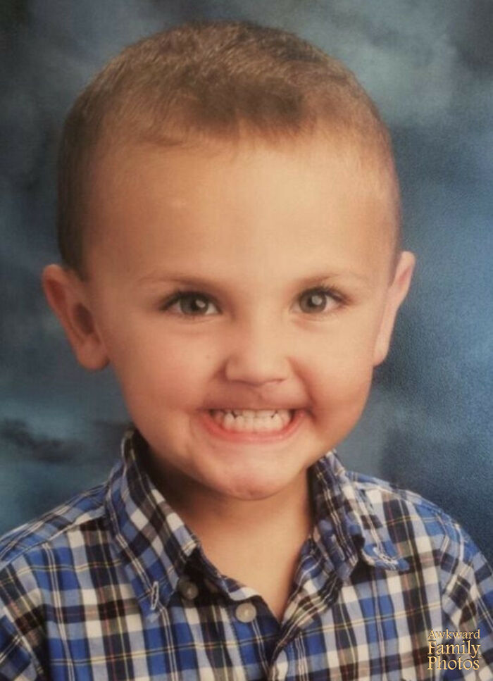 Young boy in a plaid shirt making a funny face during a classic school picture day, a memorable school picture day fail.