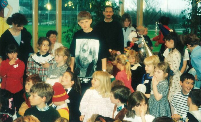 Group of children and adults at a school event, featuring a boy wearing a Nirvana shirt, capturing funny school picture day fails.