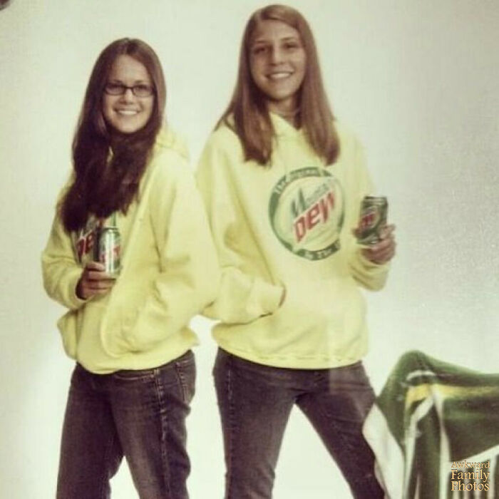 Two girls wearing matching Mountain Dew hoodies and holding soda cans in a funny school picture day fails pose.