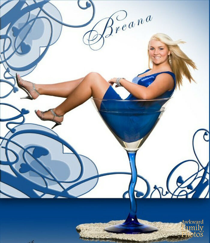 Woman in a blue dress posing inside an oversized martini glass for a funny school picture day fail photo.