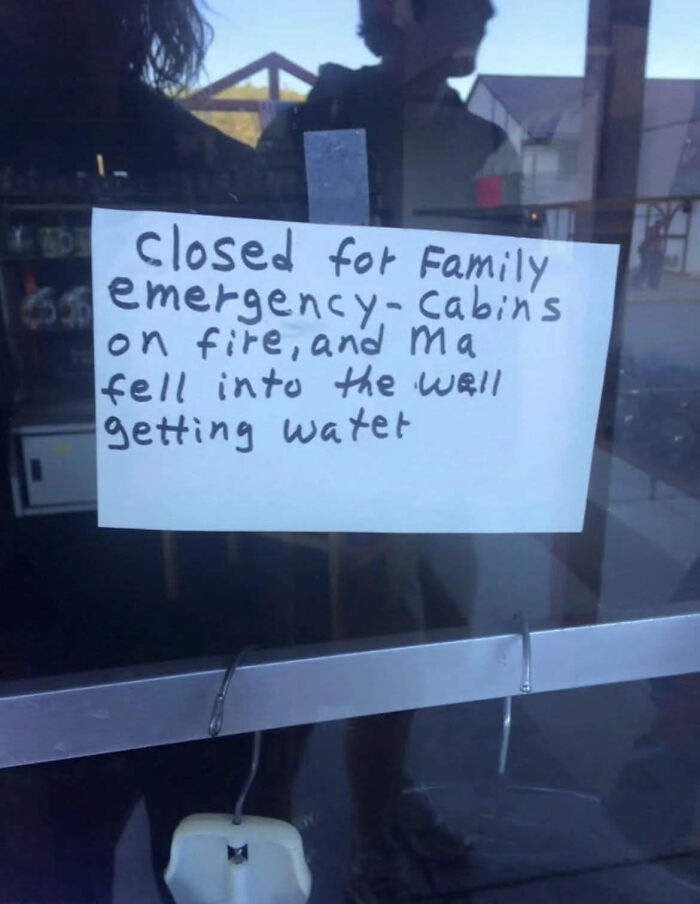 Handwritten sign on glass door explaining closure due to family emergency with cabins on fire and mom falling into a well.
