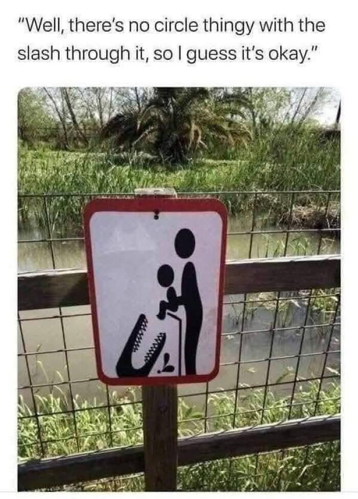 Funny caution sign showing a person holding a child near a crocodile warning people to be careful laughed at for double take humor.