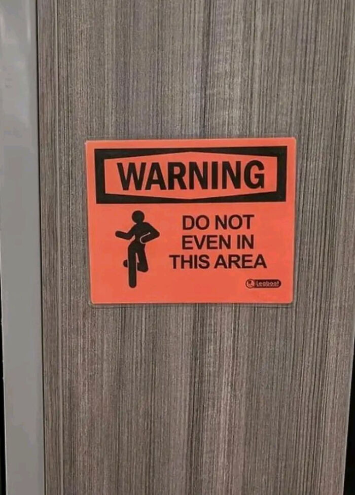 Humorous warning sign on a wooden door, making people laugh or do a double take with its unusual message.