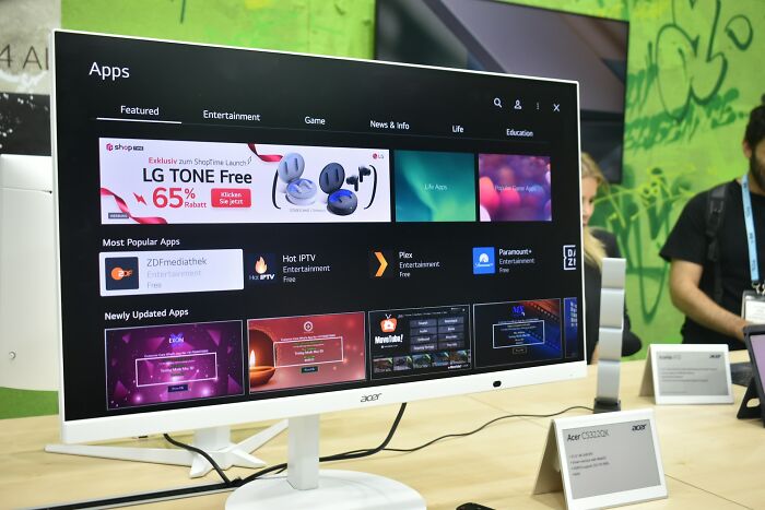 Wide computer monitor displaying app store interface with various entertainment and game apps, hinting at bizarre encounters.