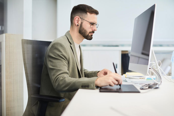 Man focused on computer screen in office, seeming busy with work while household chores are ignored. Man focused on computer screen in office, seeming busy with work while household chores are ignored.