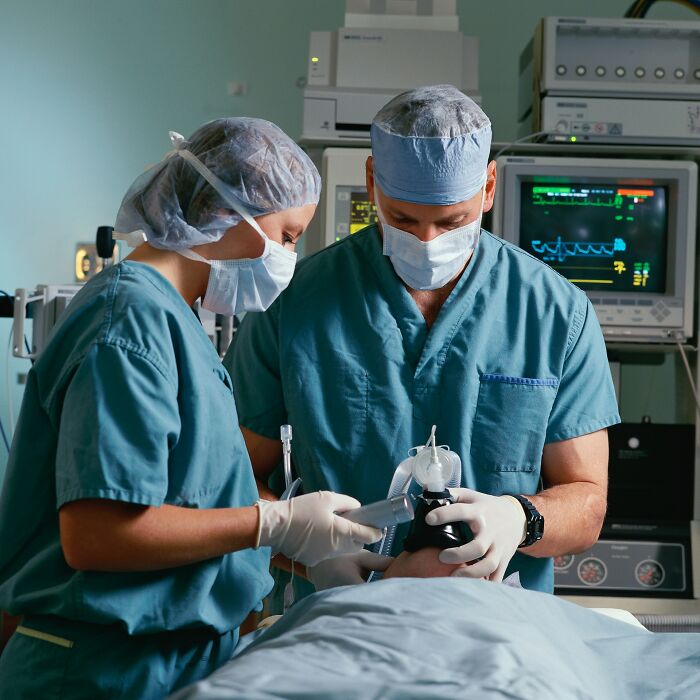 Two surgeons in scrubs and masks performing a procedure, highlighting mystery and unexplained phenomenon in medical reality.