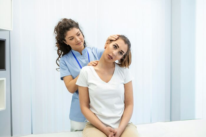 Woman receiving neck massage from therapist in clinic, illustrating moments people regretted opening their mouths.