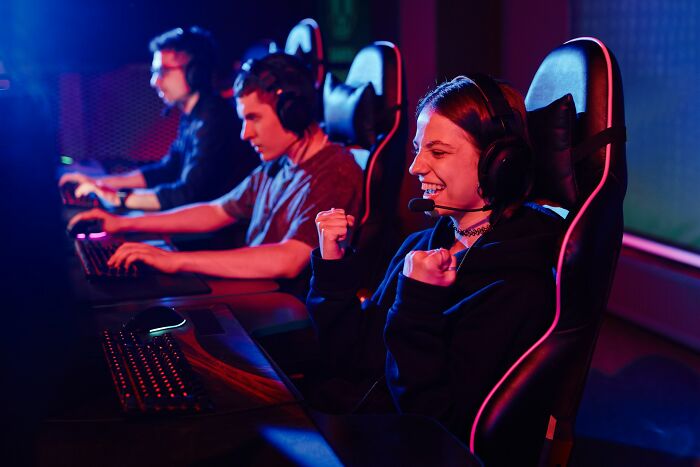 Three gamers wearing headsets playing on computers, highlighting the shaky industries at risk of collapse.