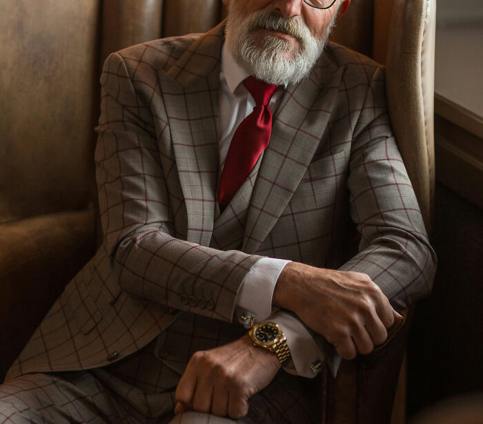 Elegant elderly man in a stylish checkered suit, illustrating moments people regretted opening their mouths and learned silence.