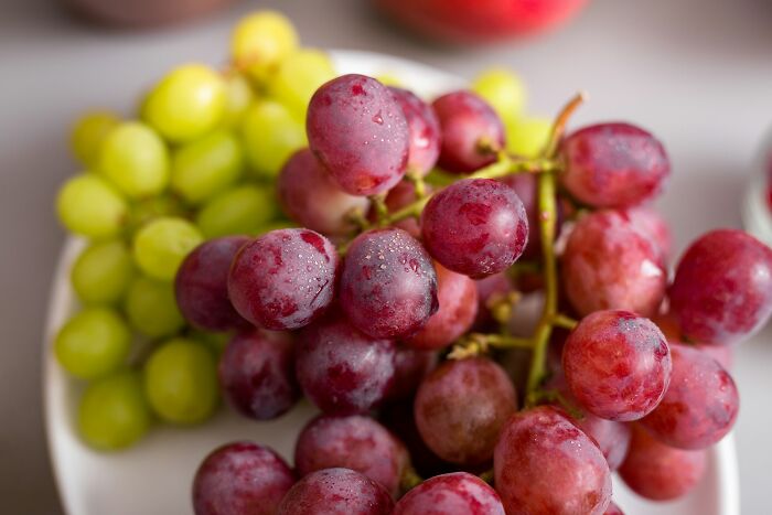 Close-up of fresh red and green grapes on a white plate, illustrating one of the scariest experiences people still can't believe.