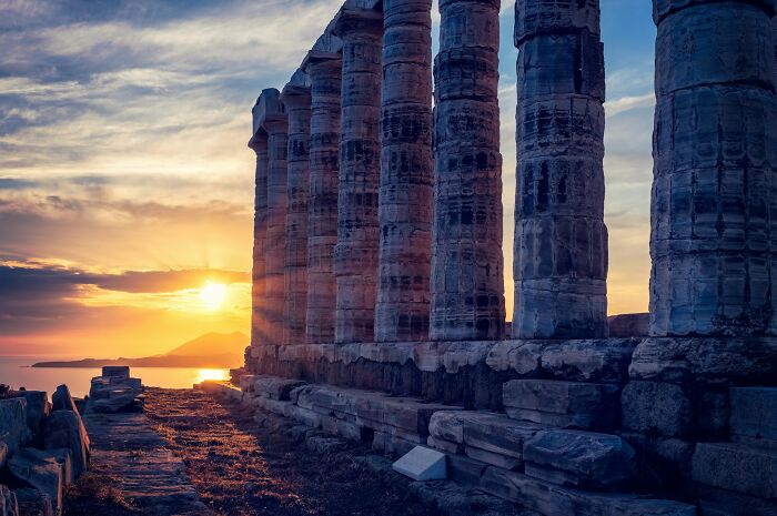 Ancient stone columns at sunset, symbolizing truths that have sadly vanished from people's home countries.