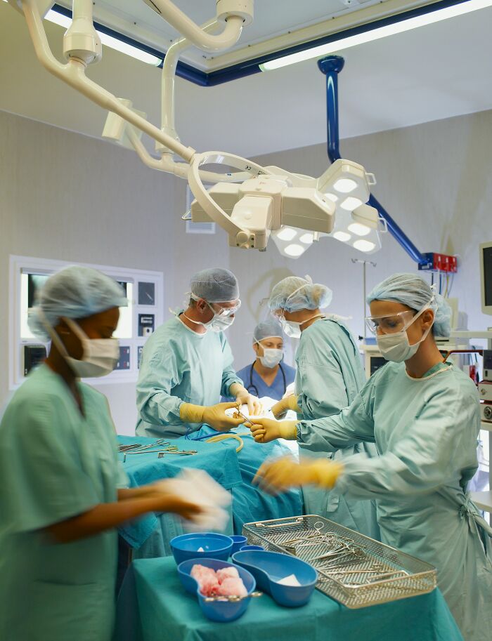 Surgical team performing an operation in a sterile environment highlighting human body design complexities.