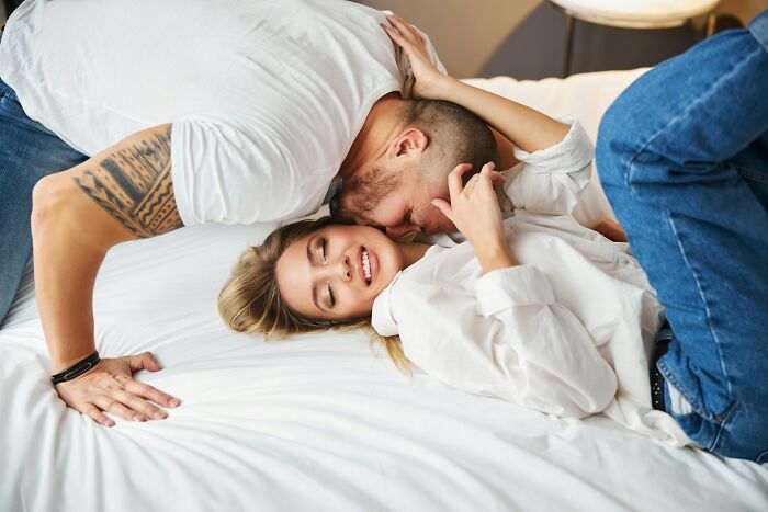 Couple embracing on bed, showing intimacy and forgiveness after cheating, highlighting reasons to forgive a cheating spouse.