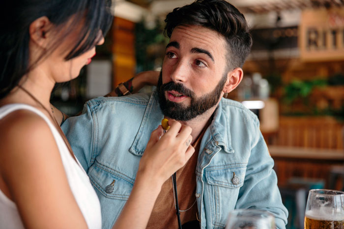 Woman confronting man in a casual setting, portraying a gold digger test situation with focused and serious expressions.