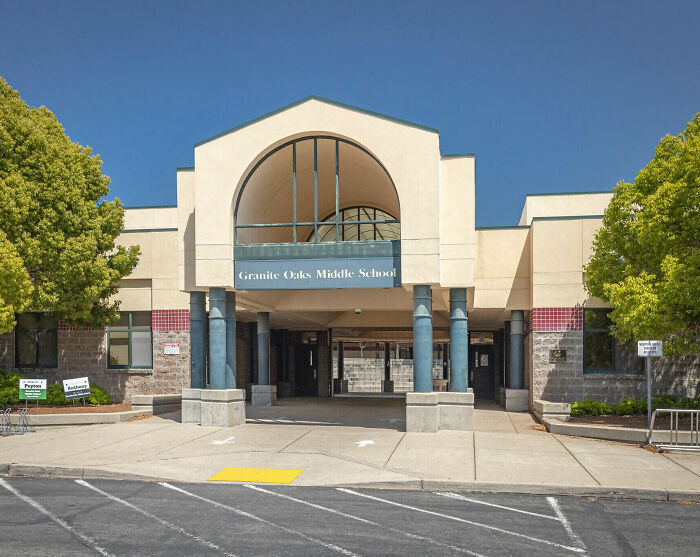 Granite Oaks Middle School entrance with trees on both sides under a clear sky, related to California teacher suspension news.