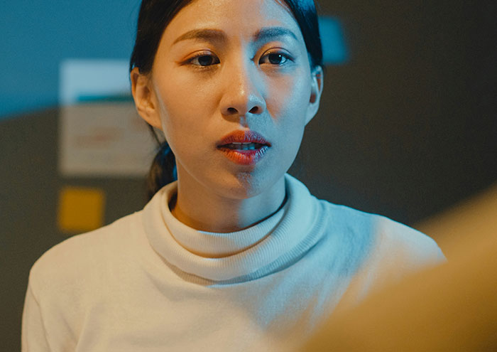 Young woman in a white turtleneck showing frustration, illustrating partners' seemingly harmless actions that drive people insane.