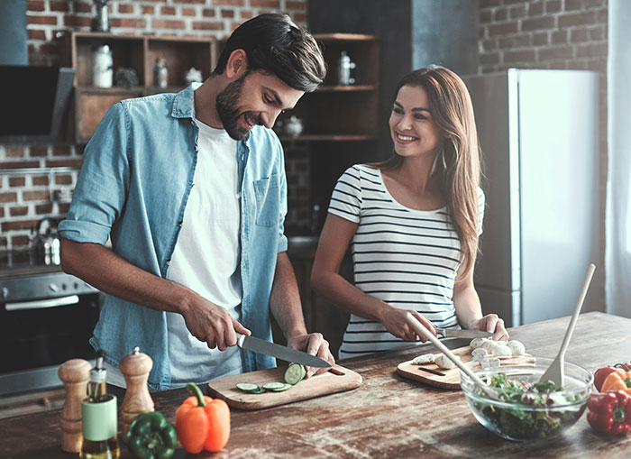 Couple preparing vegetables in a kitchen, illustrating common seemingly harmless things partners do that can annoy each other.