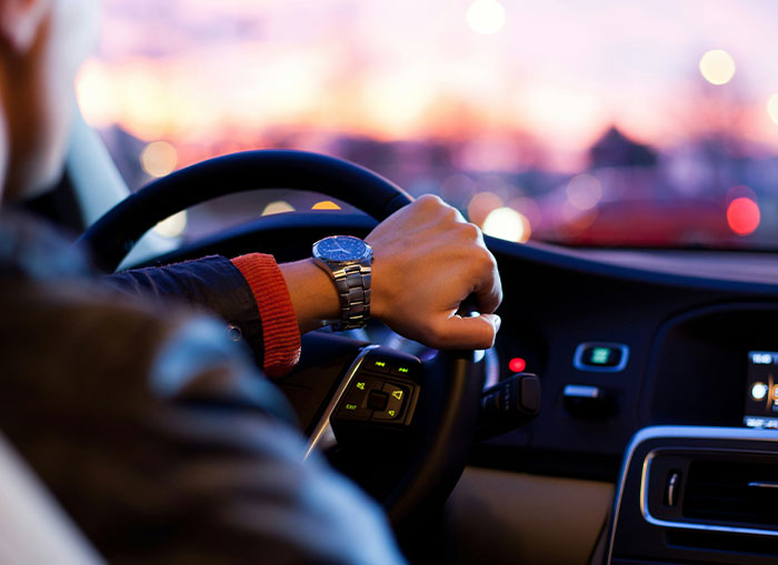 Person driving a car at dusk, illustrating seemingly harmless things partners do that still drive people insane.