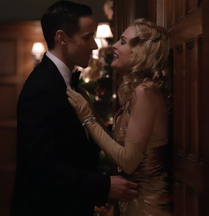 Heather Graham com um homem em traje formal, compartilhando um momento íntimo destacando a nova e estranha abordagem de filmagem de Hollywood.