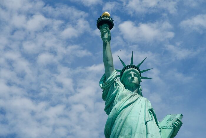 Statue of Liberty under a partly cloudy sky, illustrating popular myths about iconic landmarks worldwide.