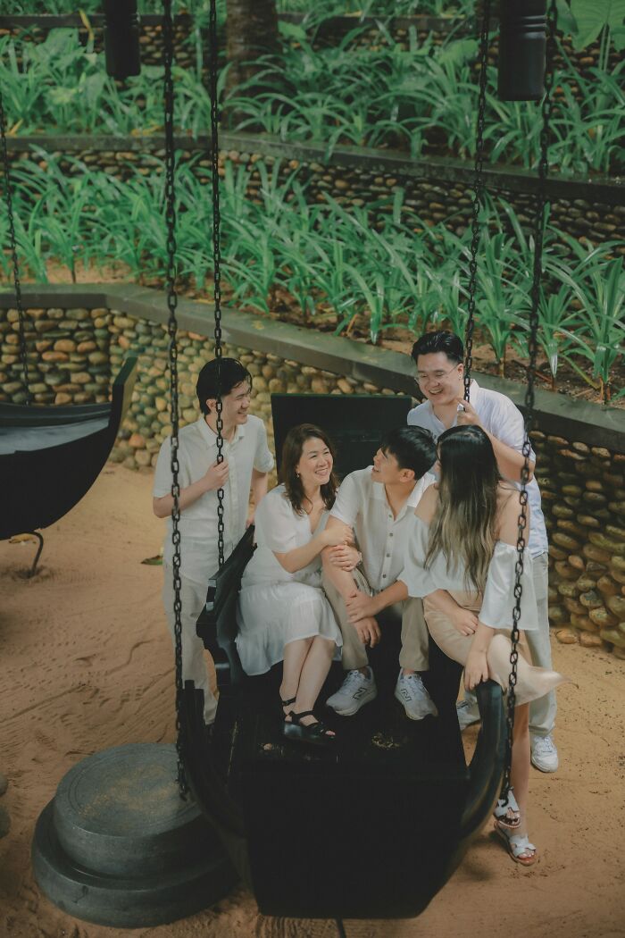 Group of people enjoying time together on swings in a garden, showcasing unique and weird family traditions.