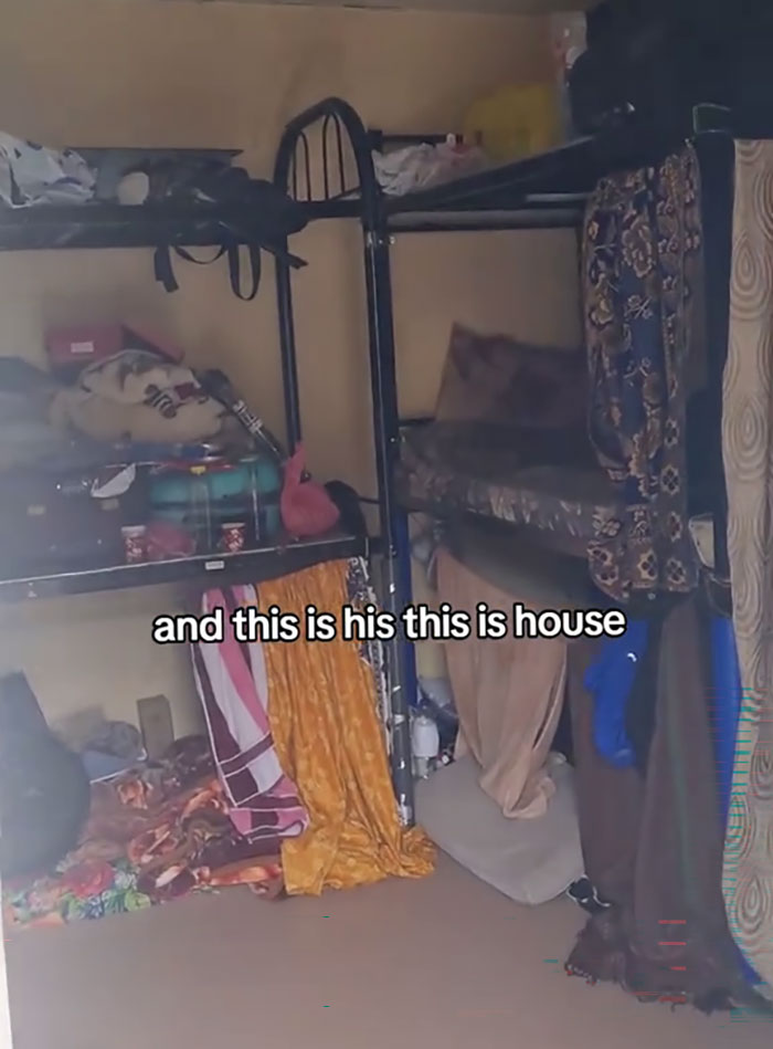 Crowded and cluttered room inside Dubai labor camps showing basic bunk beds and personal belongings stacked.