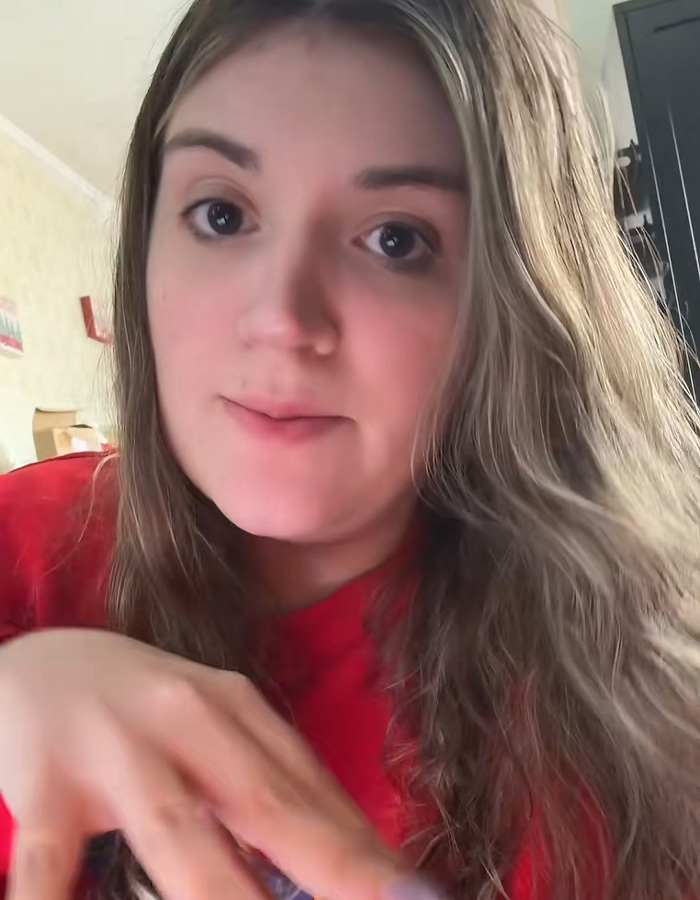 Young woman with long hair wearing a red shirt, illustrating dramatic twist with husband messaging his wife on Tinder