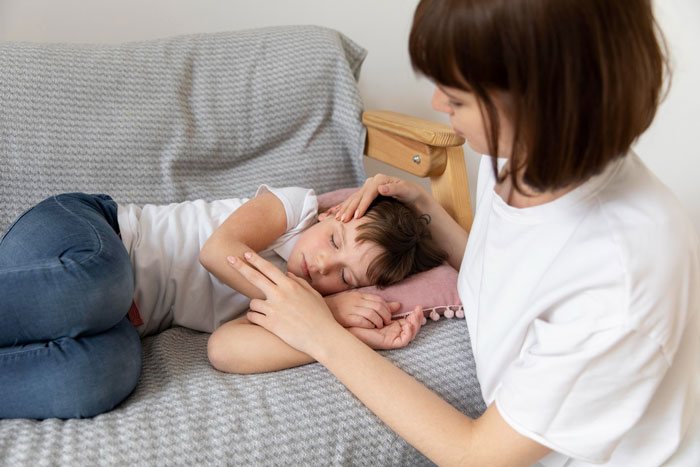 Woman comforting her sick child lying on couch, highlighting parenting duties and frustrations with excuses.