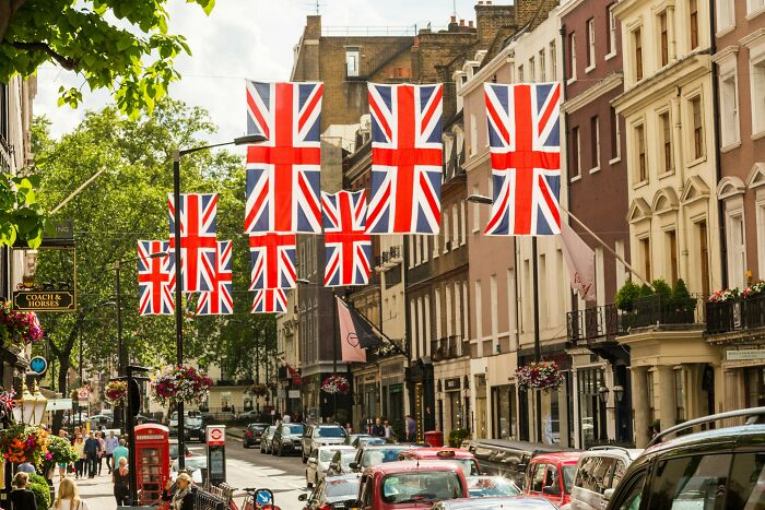Street scene in the UK with multiple British flags hanging, illustrating truths that have vanished from home countries.
