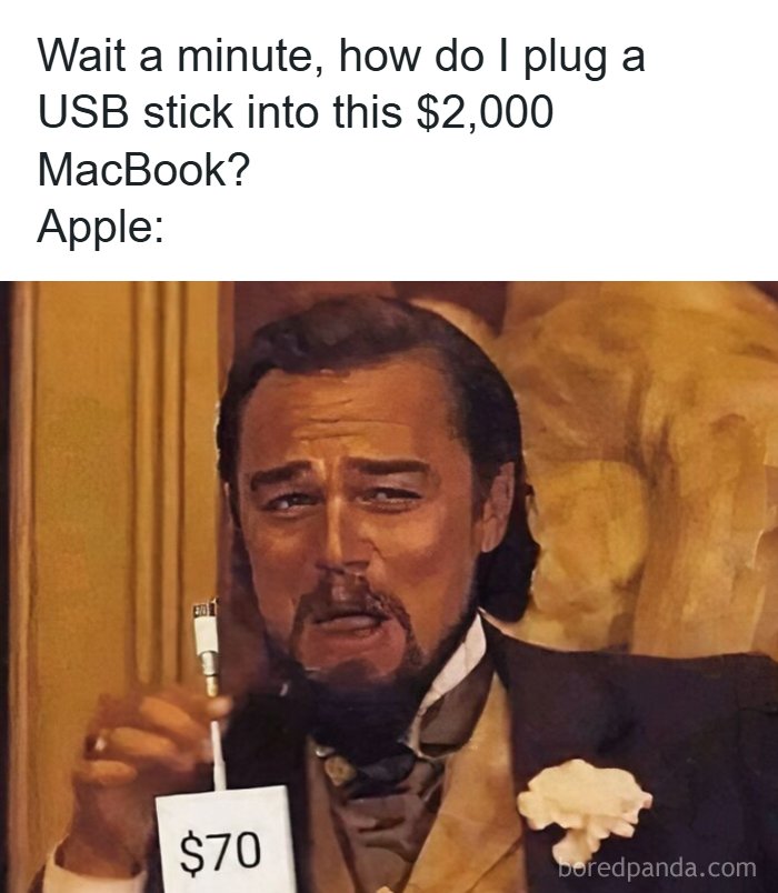 Man holding an expensive adapter showing the cost of connecting USB stick to MacBook in popular internet moments.