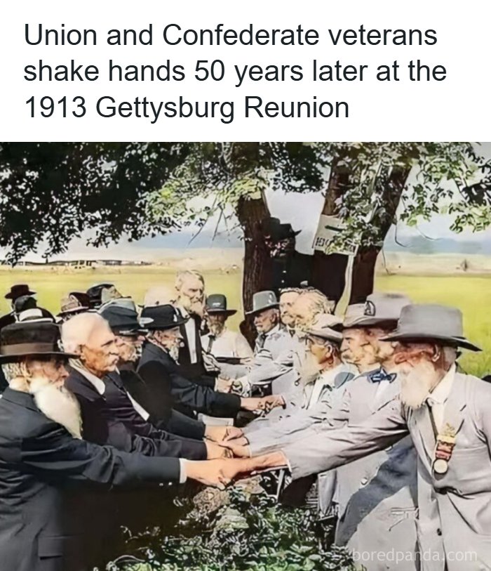 Union and Confederate veterans shaking hands 50 years later at the 1913 Gettysburg Reunion, a unique moment in history.