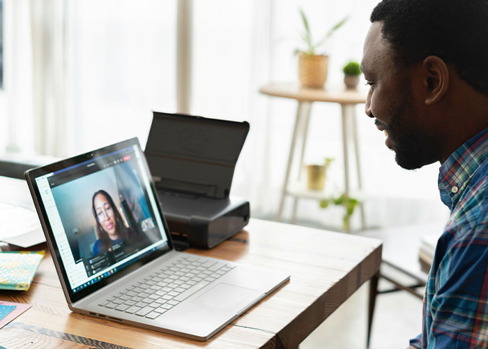 Man in a plaid shirt video chatting on laptop at home, illustrating fake facts people believed only because of movies.