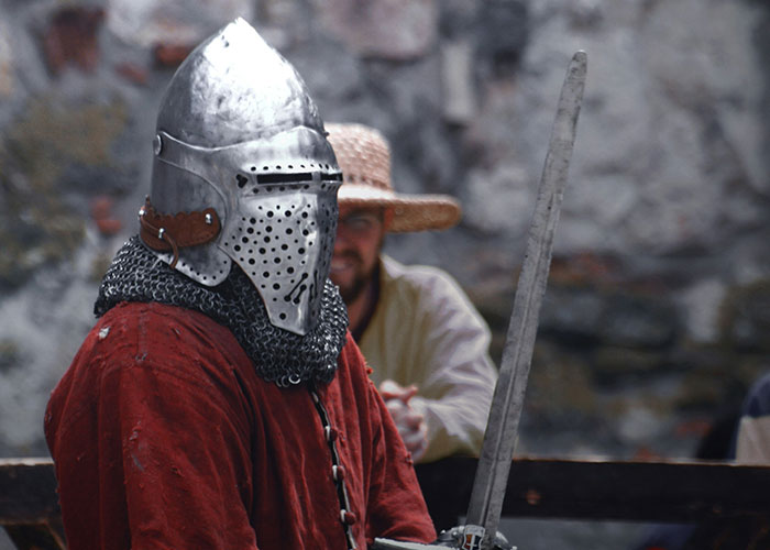 Medieval knight in full armor holding a sword, representing fake facts people believed because of movies.