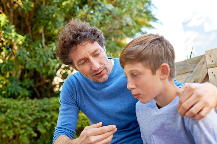 Father discussing with his son outdoors, illustrating a divorced ex using their child in ongoing conflict with the woman.
