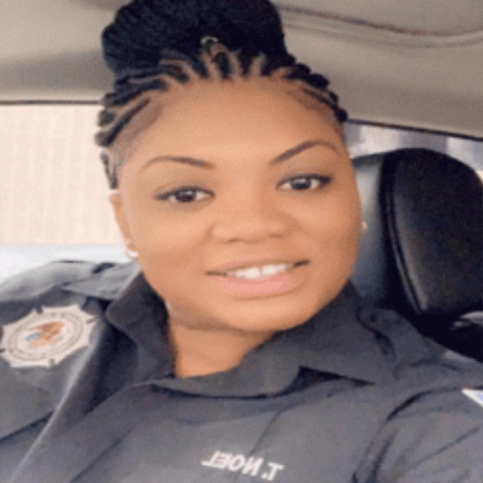 Woman in security guard uniform smiling inside a vehicle, relating to Epstein guard&rsquo;s incriminating words about passing.