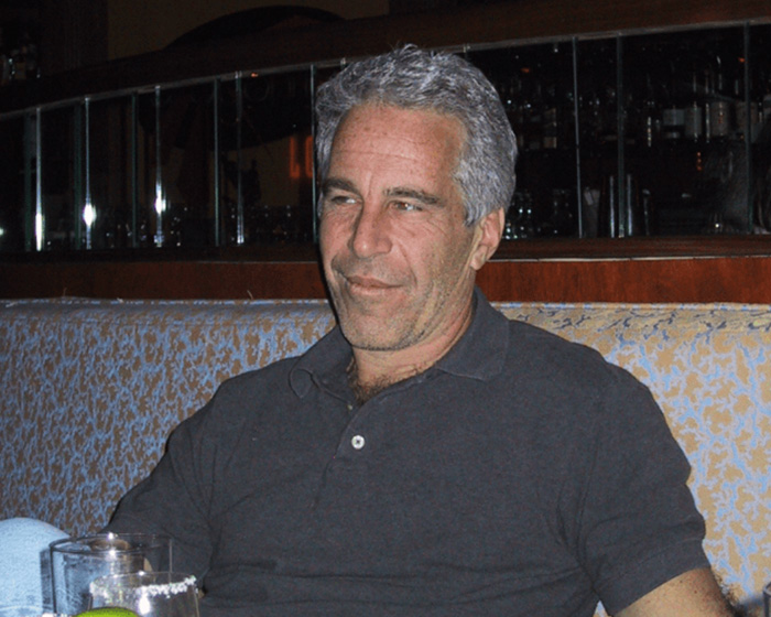 Man in a dark polo shirt sitting in a booth with a glass of water, related to Epstein guard&rsquo;s incriminating words about his passing.
