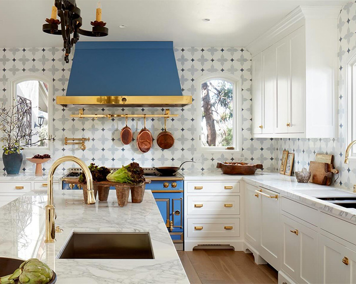 Modern kitchen with marble countertops, brass fixtures, and copper pans featured in jaw-dropping Oscars gift bag luxury.