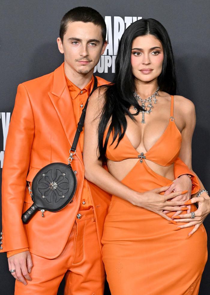 Timoth&eacute;e Chalamet and Kylie Jenner&rsquo;s ex posing together at an event, both wearing coordinated orange outfits.