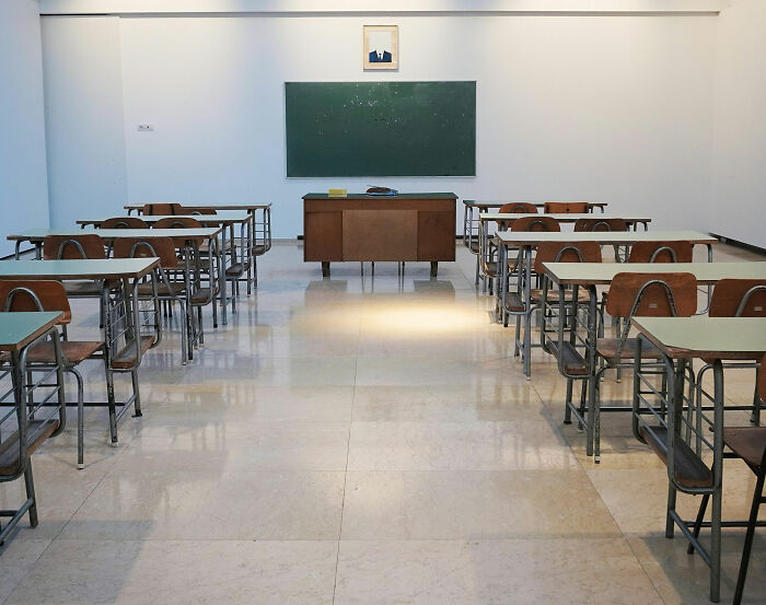 Empty classroom with wooden desks and chairs, focusing on education and California teacher incident keywords.