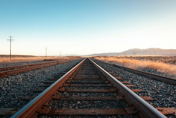 Railroad tracks stretching into the distance in a dry landscape, illustrating the concept of the older you get.