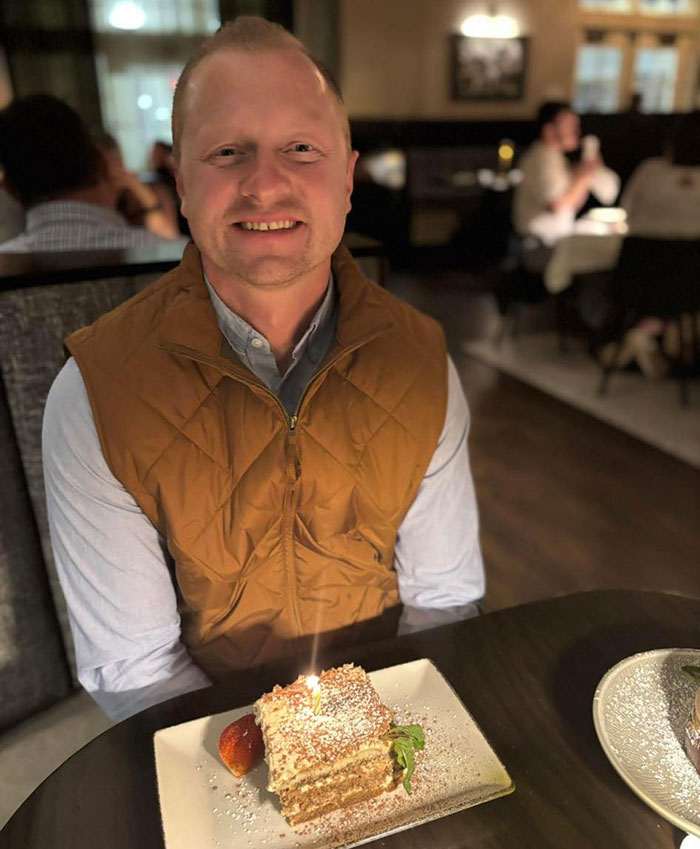 Man sitting in a restaurant with a dessert on a plate, related to Georgia teen charged in teacher&rsquo;s life prank case.