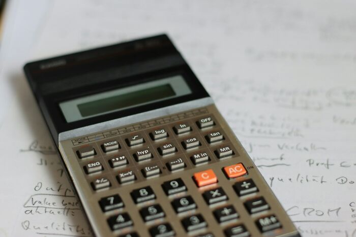Vintage scientific calculator resting on handwritten notes, symbolizing puzzling and bizarre encounters in problem-solving.