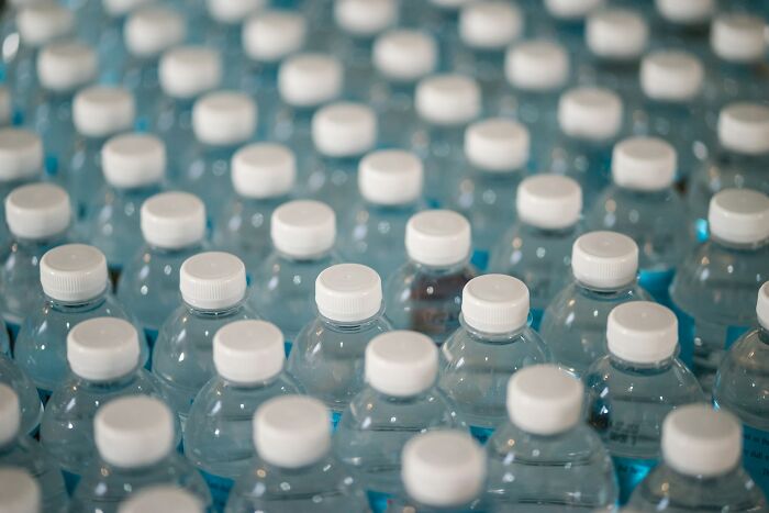 Rows of plastic bottled water representing shaky industries that can collapse if the truth is revealed.