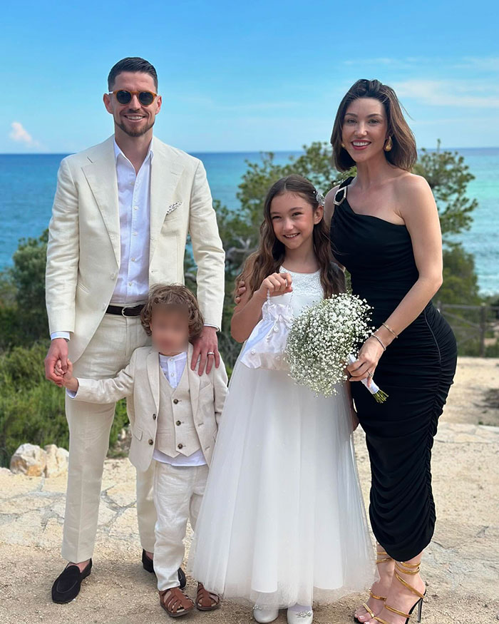 Family posing by the sea with young girl in white dress, reflecting on Chappell Roan’s background and security guard treatment.