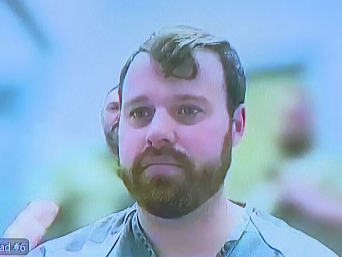 Man with beard in a casual shirt speaking about neighbor of Joseph and Kendra Duggar amid shocking allegations.