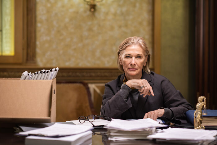 Former juror in a courtroom setting, surrounded by documents, reflecting on moments that eroded faith in the justice system.