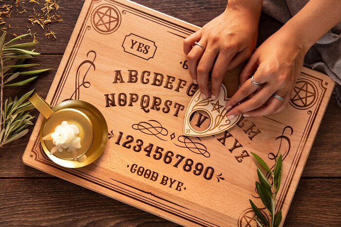 Hands using a planchette on a spirit board with symbols, highlighting moments jurors lost faith in the justice system.
