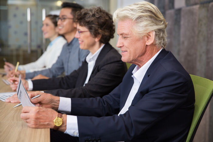 Group of former jurors sitting at a table, reviewing documents and discussing moments that made them lose faith in justice.